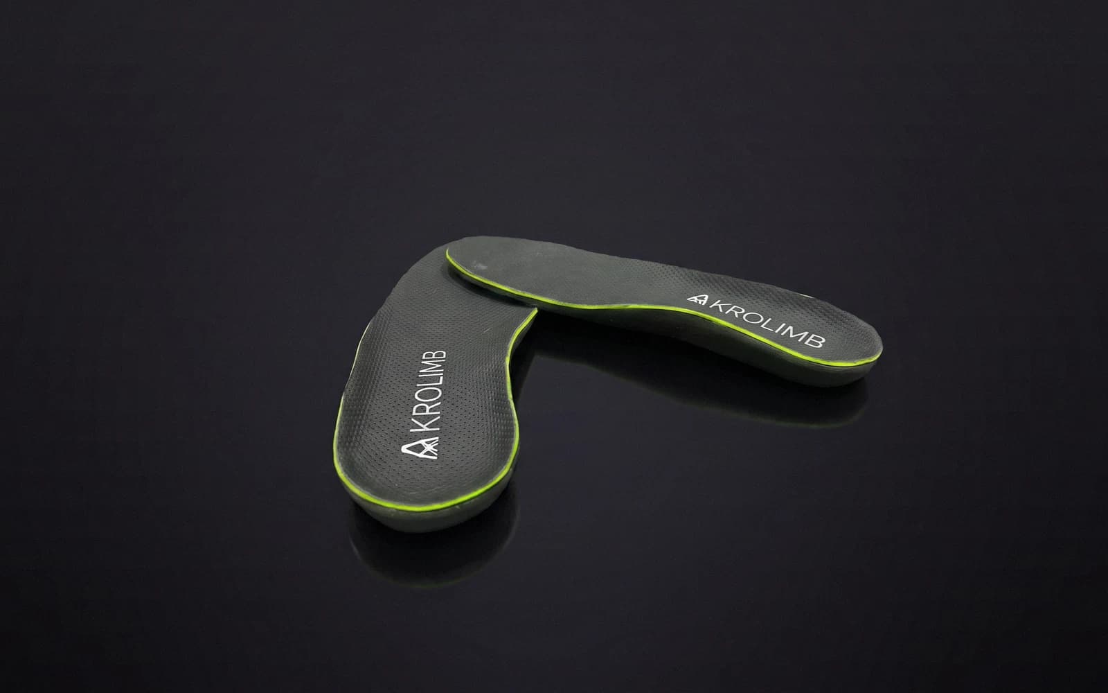 The Akrolimb Comfort Cloud pair on a dark studio stage — grey perforated tops with the lime trim, each carrying a small AKROLIMB print
