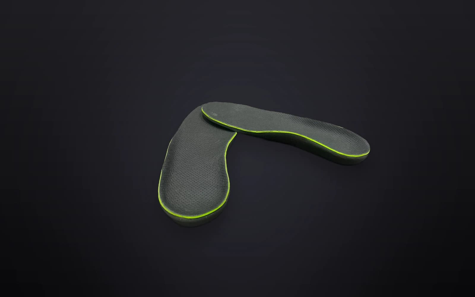 The Akrolimb Comfort Cloud insole, its lime-green accent rim catching the light on a dark studio stage